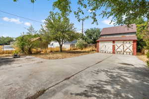 View of yard featuring an outbuilding, a barn, and a detached garage