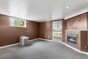 Basement featuring a glass covered fireplace, carpet floors, and recessed lighting