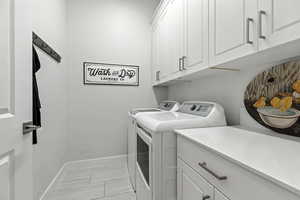 Laundry area featuring cabinet space and washing machine and clothes dryer