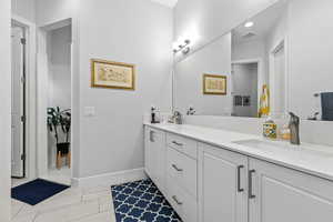 Bathroom featuring double vanity and baseboards