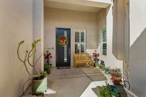 Doorway to property with stucco siding and a patio