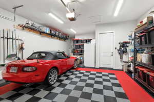 Garage with freestanding refrigerator and a garage door opener