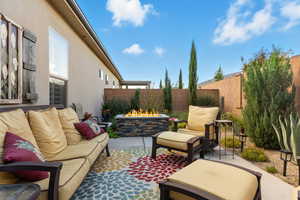 Fenced backyard featuring a patio and an outdoor living space with a fire pit