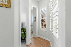 Hallway featuring light wood-style flooring and baseboards
