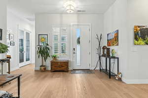 Entrance foyer with light wood-style flooring and french doors