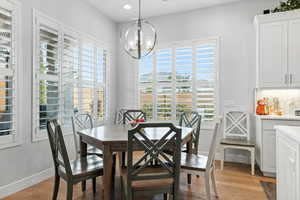 Dining space featuring light wood-style flooring, a chandelier, and recessed lighting