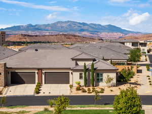 View of front of home featuring stucco siding, a mountain view, an attached garage, concrete driveway, and a tile roof