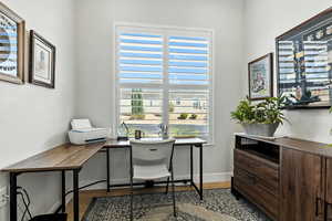 Office with dark wood-style floors and baseboards