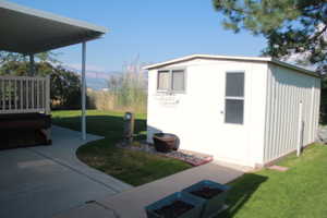 View of grassy yard featuring a storage unit