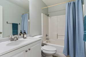 Bathroom featuring shower / bath combination with curtain and vanity