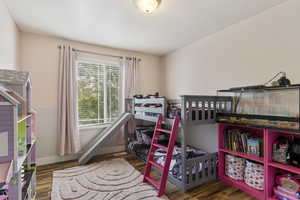 Bedroom featuring dark wood finished floors and baseboards