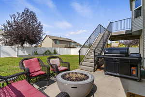 Fenced backyard with a patio area, stairs, an outdoor fire pit, a grill, and a deck