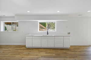Kitchen with white cabinetry, recessed lighting, and light wood finished floors