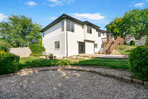 Back of house with stairway, a patio, brick siding, a deck, and a gate