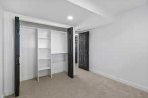 Unfurnished bedroom with light colored carpet, a closet, and recessed lighting