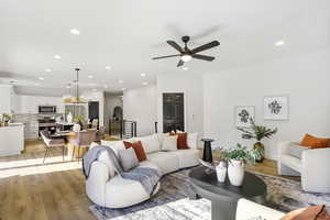 Living area featuring recessed lighting, light wood-type flooring, a ceiling fan, and a chandelier