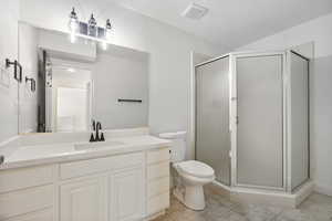 Bathroom featuring a shower stall, vanity, and light tile patterned flooring