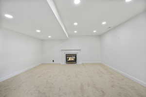 Basement with recessed lighting, carpet floors, and a fireplace
