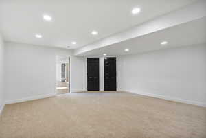 Basement with recessed lighting and light colored carpet