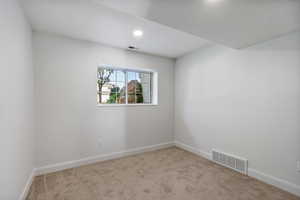 Carpeted spare room with baseboards and recessed lighting