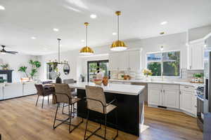 Kitchen featuring decorative light fixtures, white cabinetry, recessed lighting, a kitchen island, and light wood-style flooring