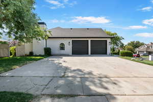 View of front of property featuring driveway, a shingled roof, a chimney, an attached garage, and a front yard