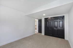 Unfurnished bedroom with carpet flooring, a closet, and recessed lighting