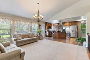 Living room with lofted ceiling, a chandelier, and light tile patterned floors