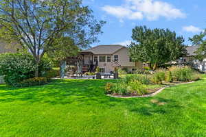 Rear view of property featuring a patio area, stucco siding, a yard, and a pergola