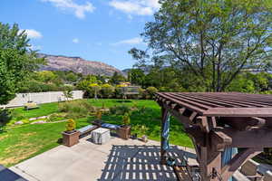 View of patio featuring an outdoor fire pit, a mountain view, and view of wooded area