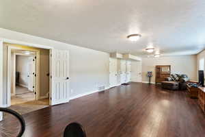 Living area featuring dark wood-style flooring and a textured ceiling