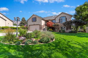 View of front of property featuring stucco siding, a garage, and brick siding