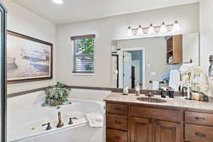 Full bath with vanity and a tub with jets