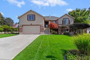View of front of home featuring a garage, stucco siding, concrete driveway, and brick siding