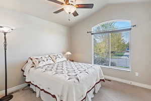 Bedroom featuring vaulted ceiling, a ceiling fan, and light colored carpet