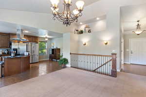 Kitchen featuring dark tile patterned flooring, island exhaust hood, recessed lighting, freestanding refrigerator, and pendant lighting