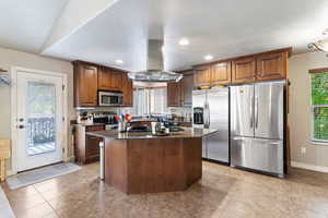 Kitchen with plenty of natural light, stainless steel appliances, dark stone countertops, island range hood, and recessed lighting
