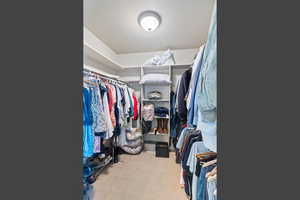 Spacious closet with light colored carpet
