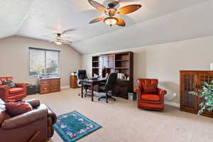 Office featuring lofted ceiling, light colored carpet, a ceiling fan, and a textured ceiling