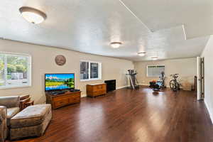 Workout room with a textured ceiling and dark wood finished floors