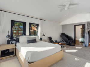 Bedroom featuring carpet flooring, lofted ceiling, ceiling fan, and tile patterned floors