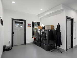 Laundry room with recessed lighting and separate washer and dryer