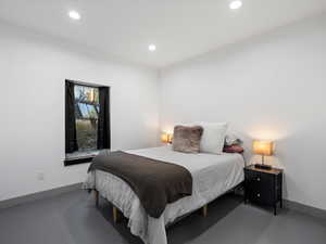 Bedroom with recessed lighting and concrete floors