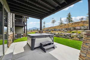 View of patio / terrace with a mountain view and a hot tub