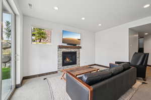 Living area with recessed lighting, a fireplace, carpet floors, and stairs