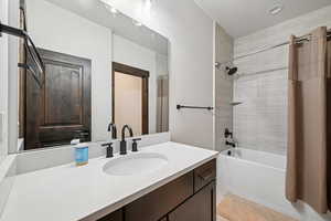 Full bathroom with shower / bath combo with shower curtain and vanity