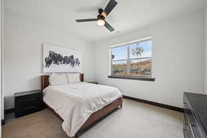 Bedroom featuring a ceiling fan and carpet