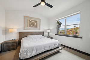 Carpeted bedroom with lofted ceiling, a ceiling fan, and a mountain view