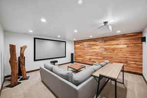 Cinema room featuring wood walls, recessed lighting, and light colored carpet