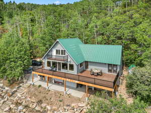 View of property featuring a gorgeous brand new TREX deck with unbelievable views, a metal roof, outdoor dining area, and a mountain/valley view